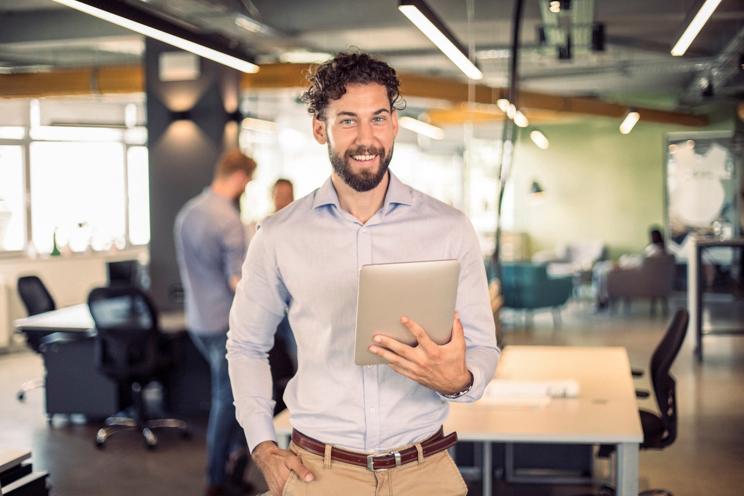 Happy Businessman at the Office Using a Digital Tablet